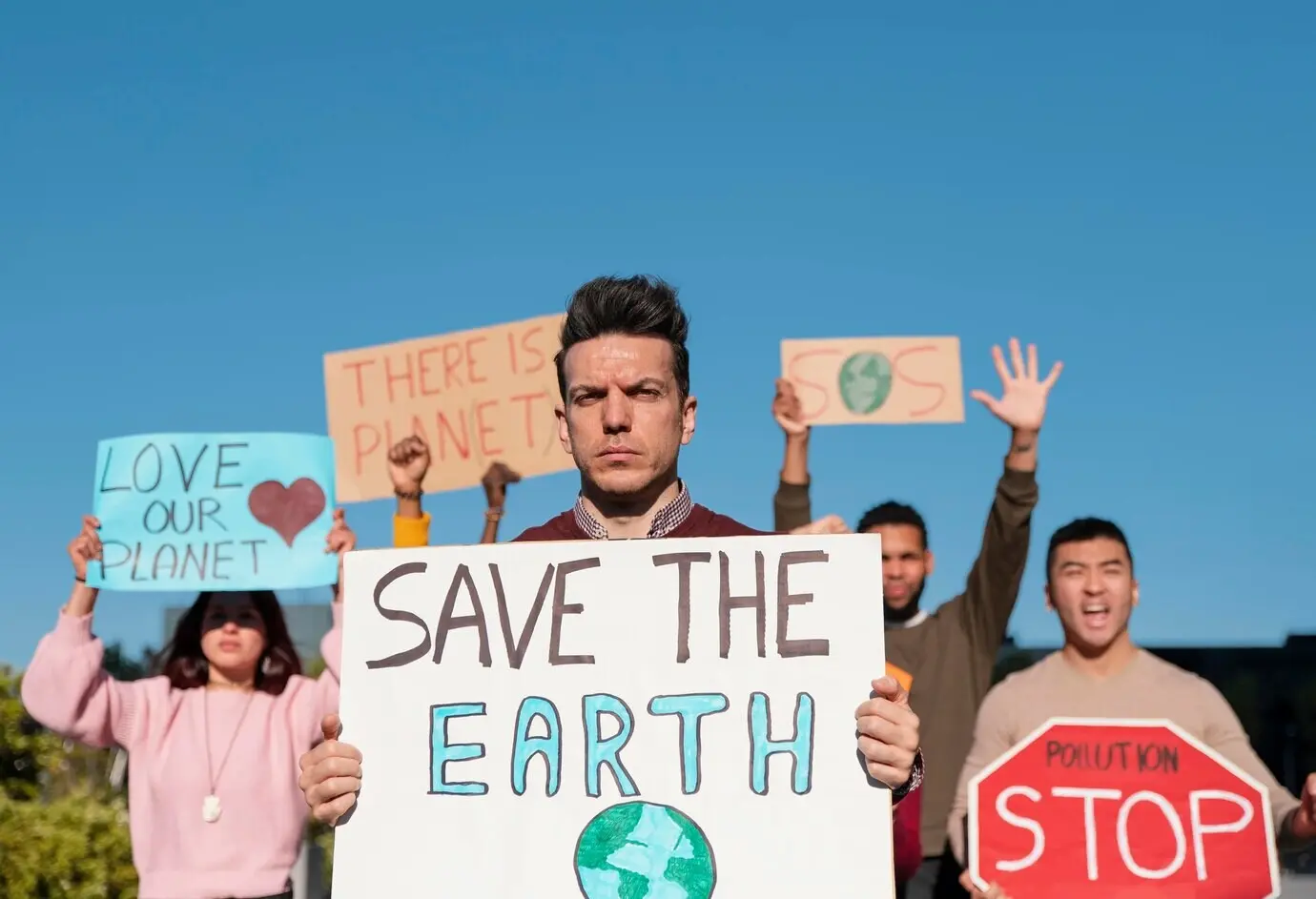 Средний план людей, протестующих с плакатами.